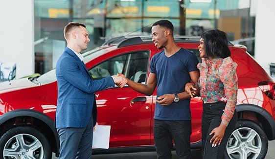 People shopping for a car at a dealership