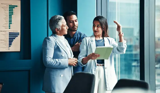 Political campaign team reviewing performance data on a tablet to optimize outreach and compliance.
