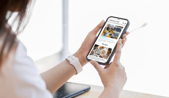 Person holding a smartphone and scrolling through local content, showing how multi-location digital marketing reaches consumers when intent is high.