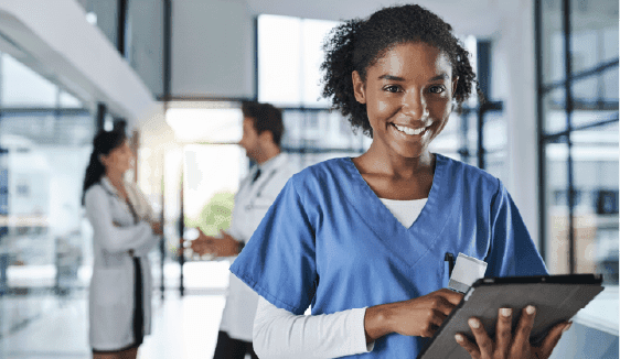 Nurse holding a digital tablet in a hospital corridor, representing privacy-focused patient engagement and compliant targeting in healthcare marketing.