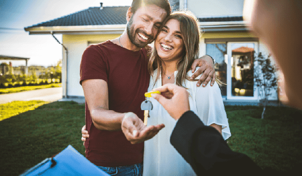 A family standing outside of their new home